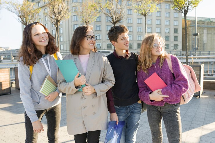 group-students-with-teacher-teenagers-talking-female-teacher_116407-5236